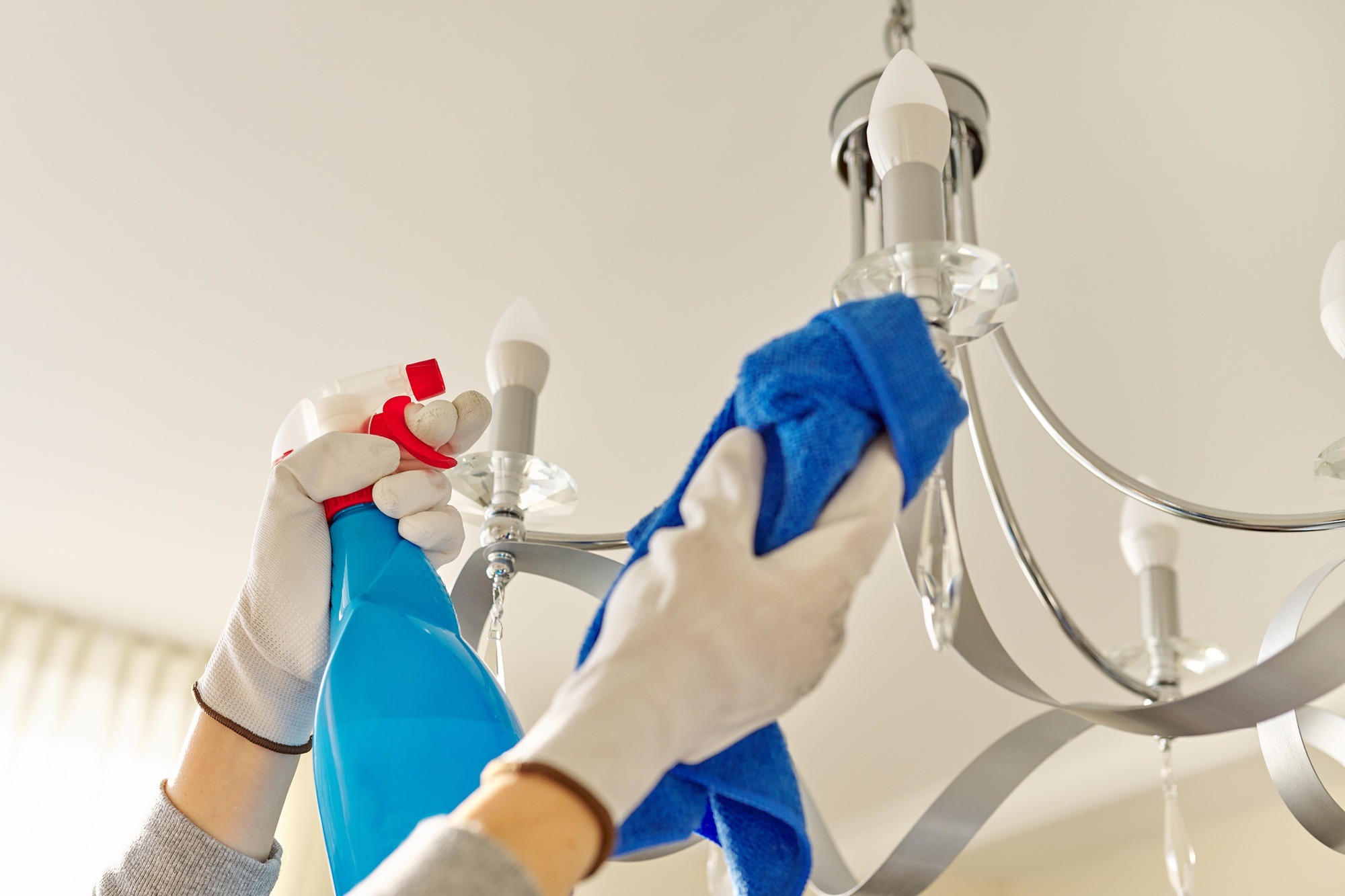 House cleaning, close-up of hands cleaning and polishing lamp